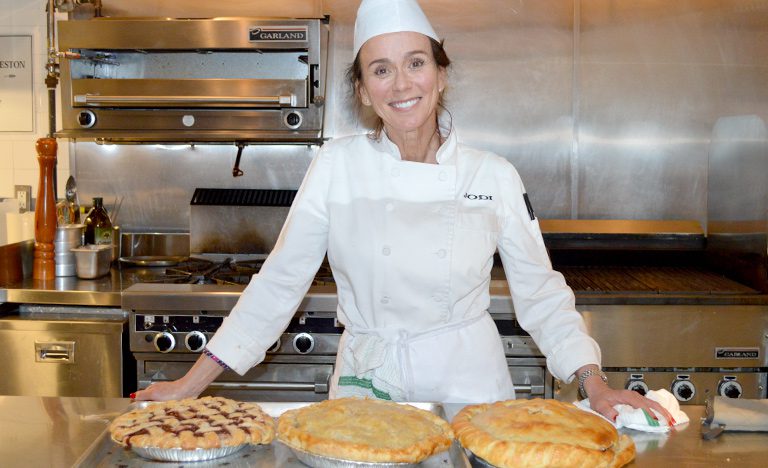 Cooking for Life volunteer Jodi standing next to some baked pies, donating her time and food items to homeless youth in Toronto